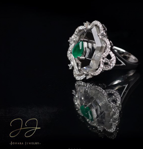 خاتم من الكوارتز الأبيض مصنوع من الذهب الأبيض عيار 18 مرصع بلالماس الأبيض ومزين بالزمرد الأخضر في المنتصف