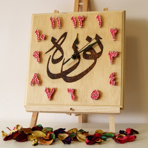 ساعة حائط خشبيه بالمسامير مع الأسم مكتوب بإستخدام...