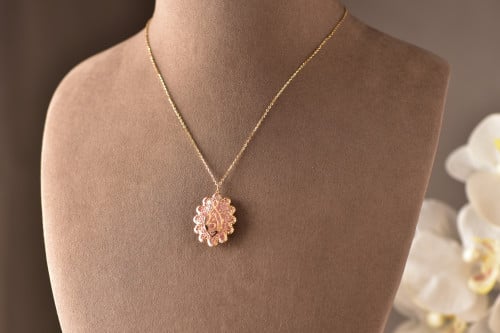 عقد من الذهب عيار 18 محلًى بالصدف ومنحوتة فيه كلمة...