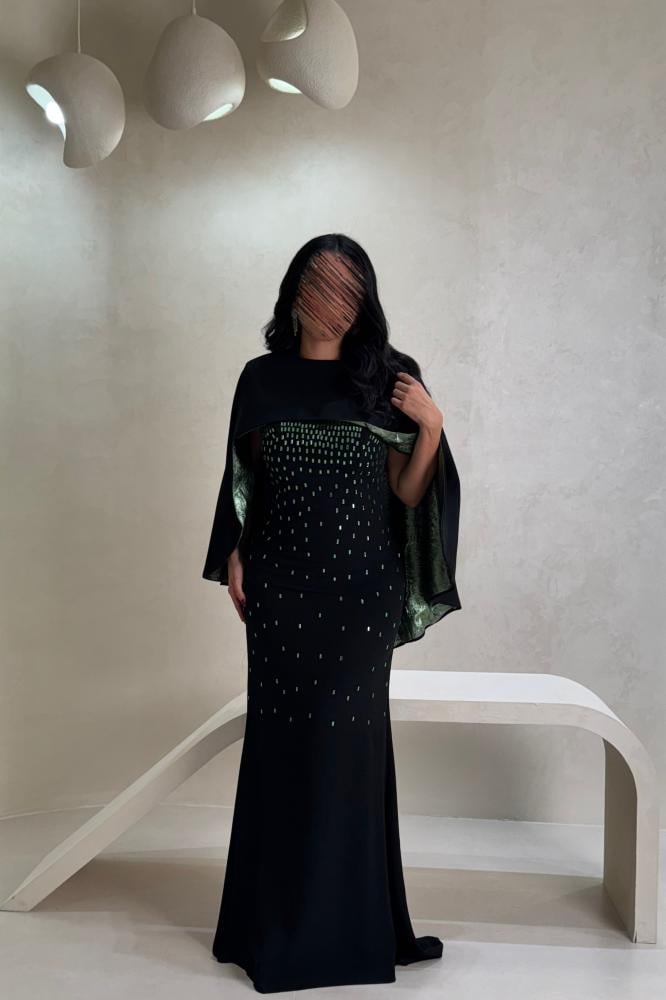 فستان أسود بتفاصيل خضراء لامعة بتصميم فاخر