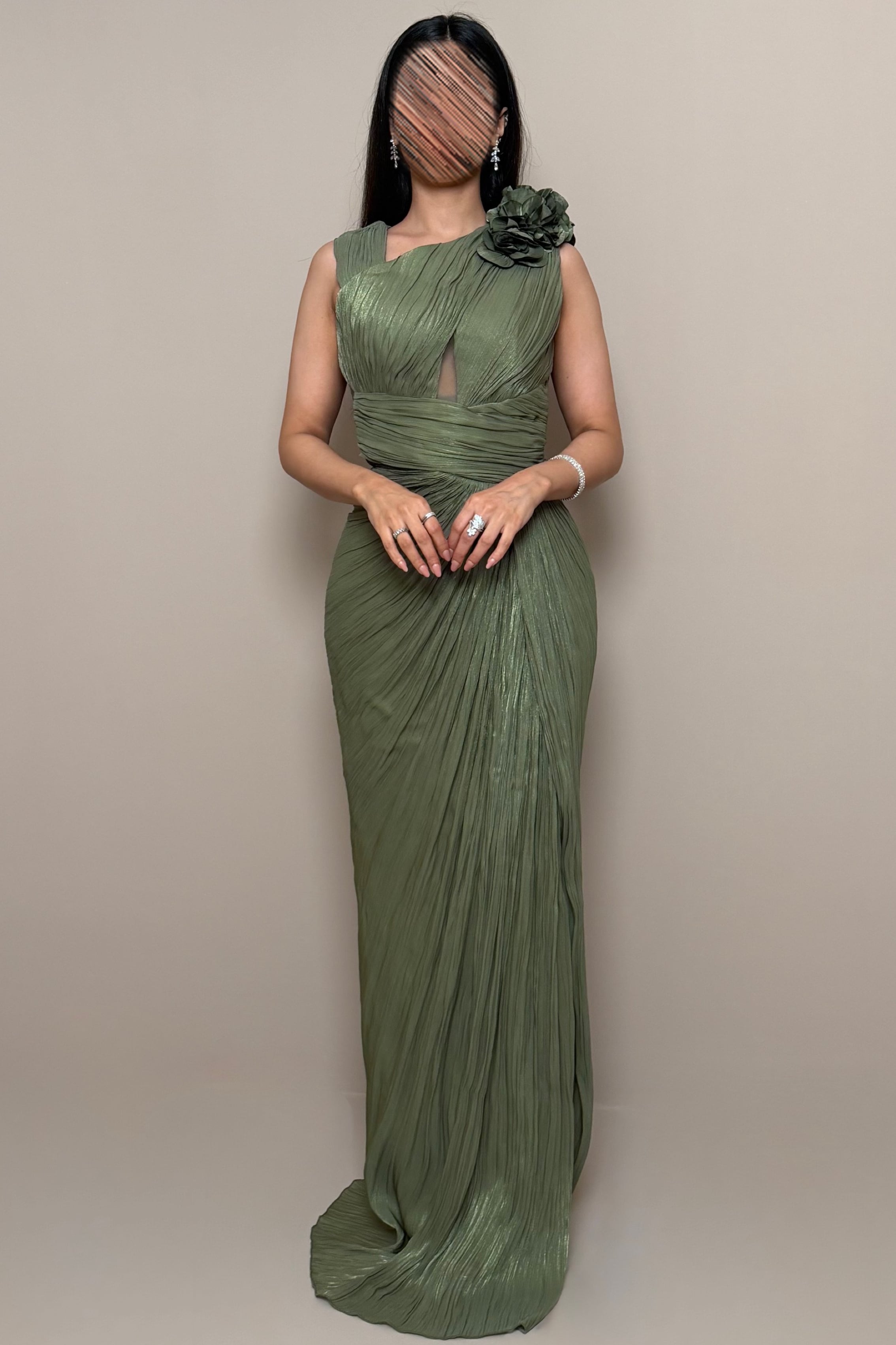 An olive green evening dress with a floral detail on the shoulder. -