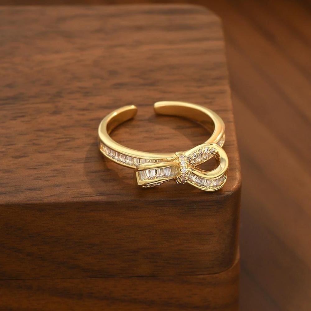 خاتم نسائي تصميم شكل فيونكة مطلي ذهب ومزين بالزاركون