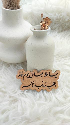 خشبية باسماء العريسين وعبارة "ياحظ عباس يوم فاز بق...