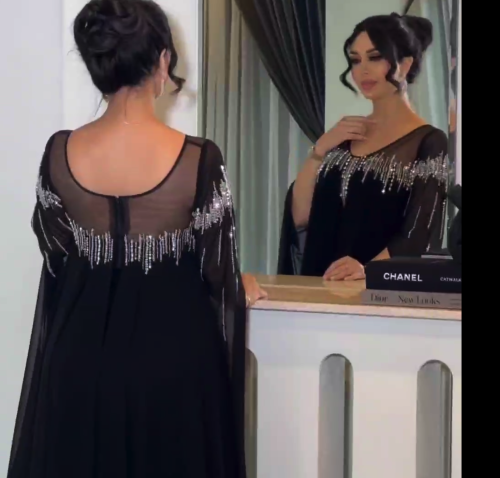 فستان سهرة أسود بأكمام شفافة مطرزة يدويًا