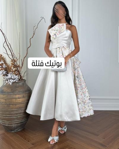 فستان رصاصي بلمعة بأكتاف مكشوفة وتفاصيل زهور ملونة