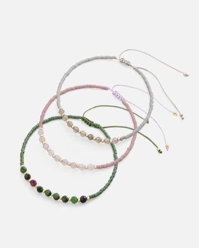 Bracelets made of threads and beads in pink, green and gray