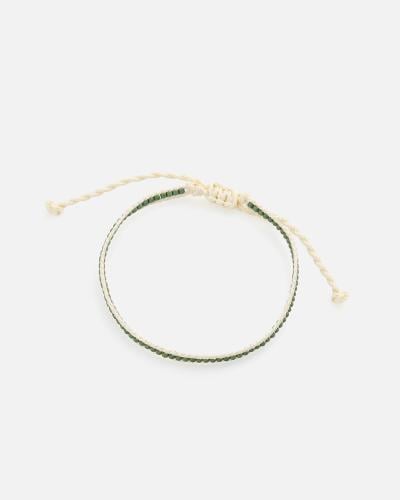 A bracelet made of beige threads and green beads
