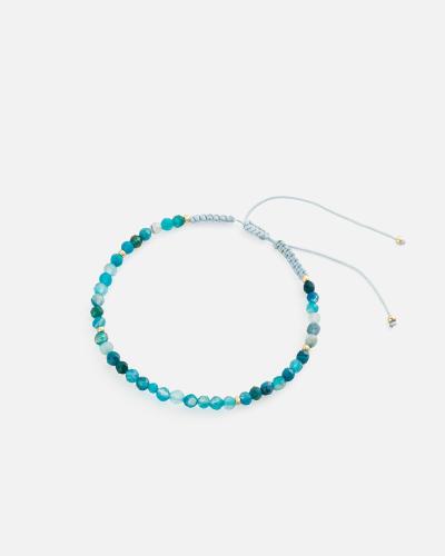 Women's bracelet with woven threads and blue beads