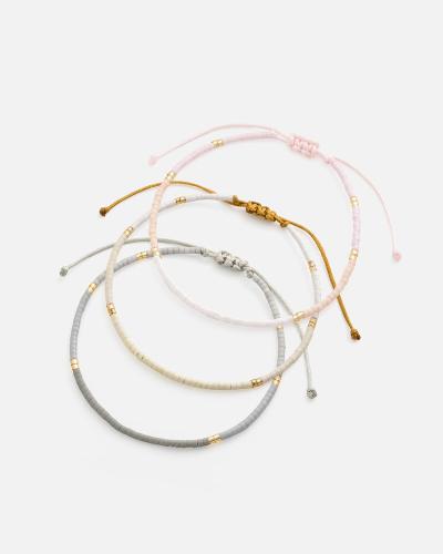 Bracelets made of threads and beads in pink, gray, and beige