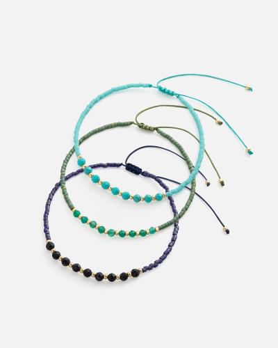 Bracelets made of threads and beads in turquoise, olive, and purple.