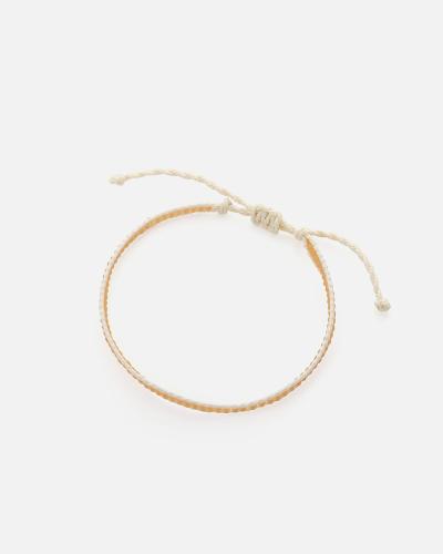 A bracelet made of beige threads and light brown beads