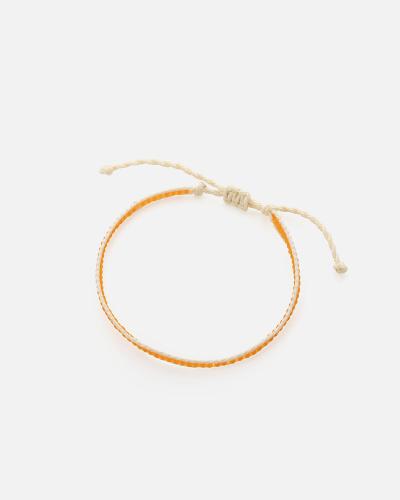 A bracelet made of beige threads and orange beads