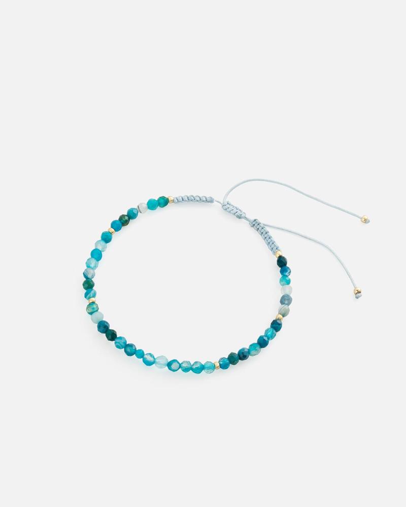 Women's bracelet with woven threads and blue beads