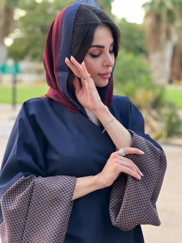 عباية عملية اللون كحلي و الأكمام عنابي مشجر و على الطرحة شك عنابي