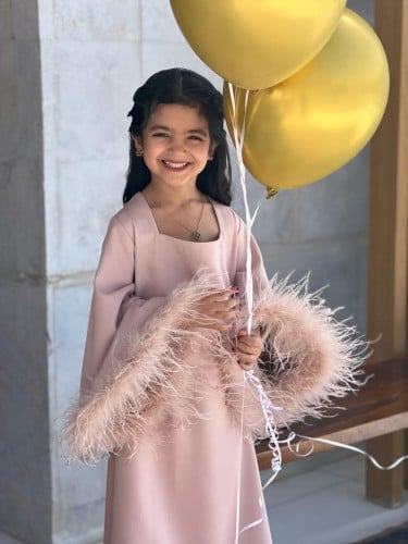 جلابية للأطفال القماش تفته وردي وعلى الأكمام ريش