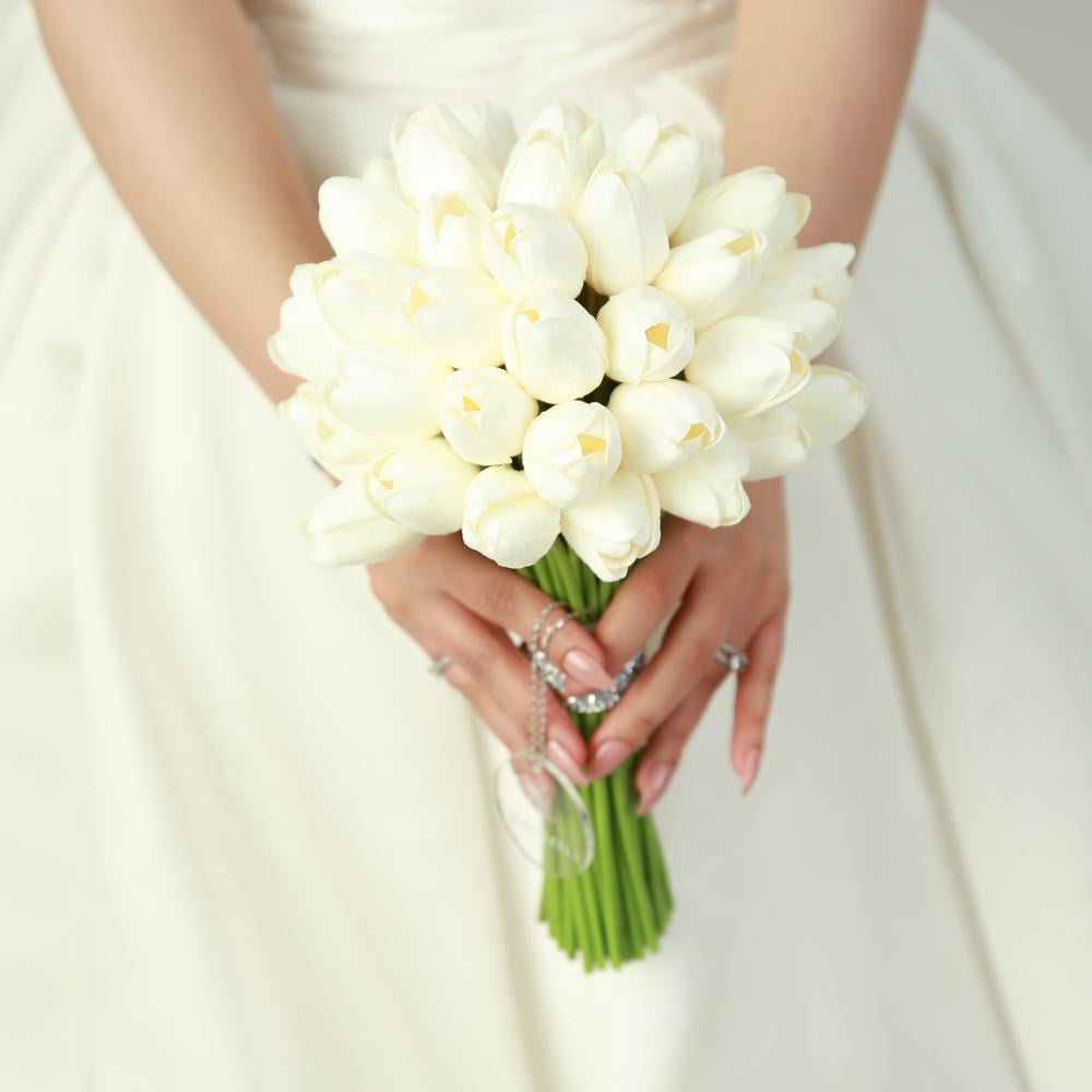 مسكة زفاف أنيقة بزهور توليب بيضاء صناعية وتفاصيل فضية براقة