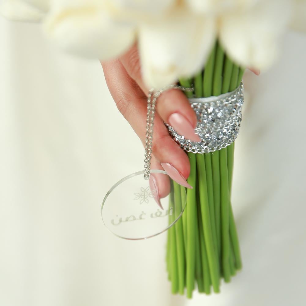 مسكة زفاف بزهور توليب بيضاء وشريطة مزينة بالكريستال تصميم أنيق