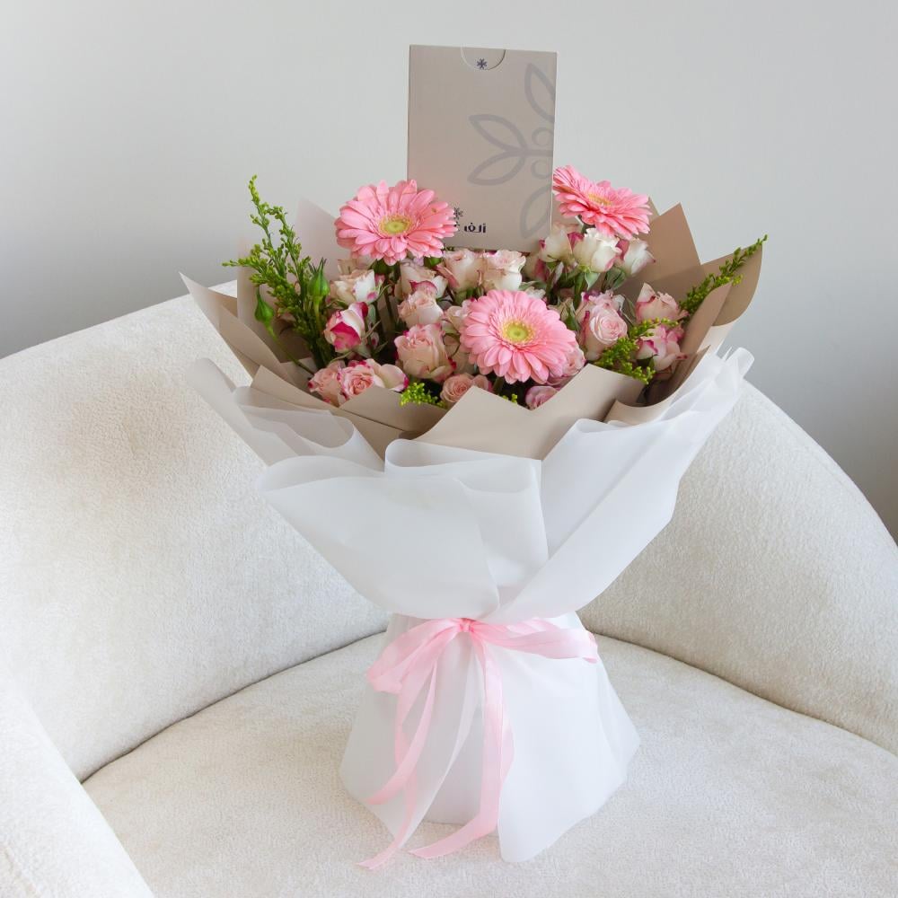 باقة ورد طبيعي بتغليف أبيض وورد وردي أنيق