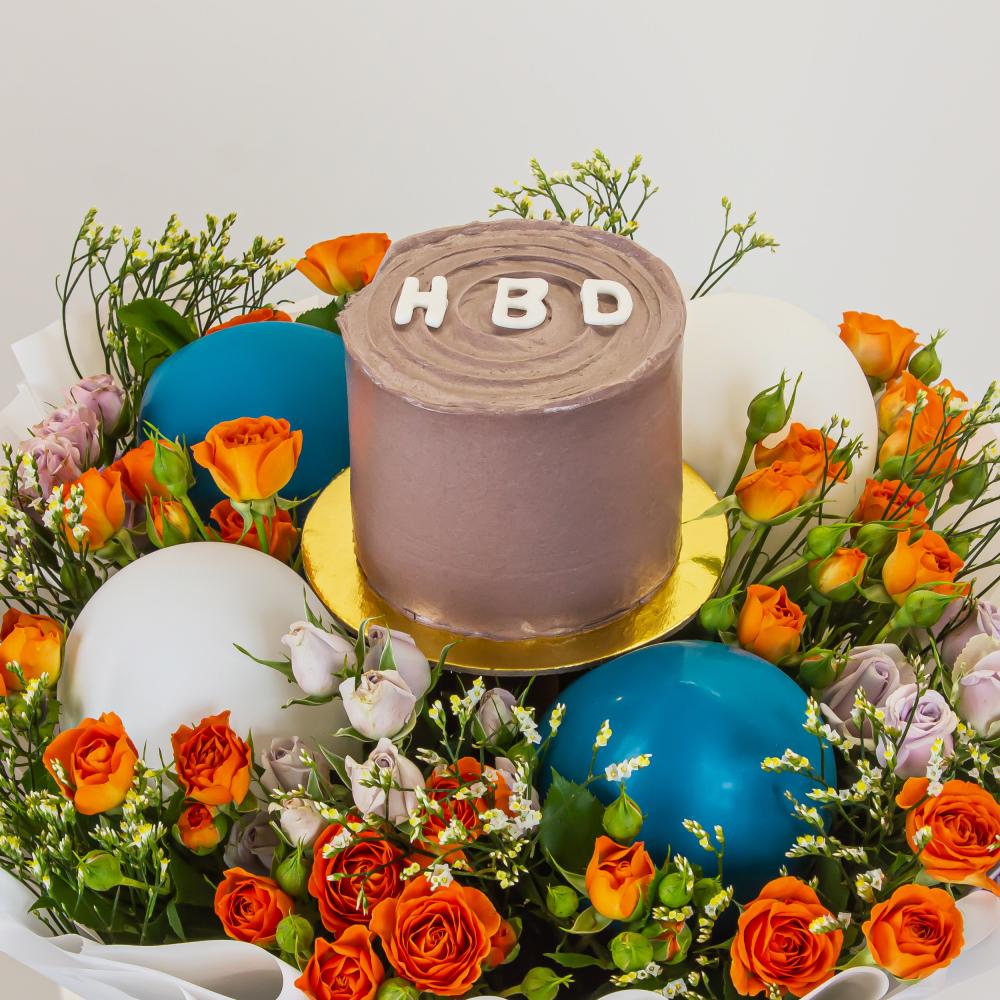 هدية عيد ميلاد تجمع بين الزهور الطبيعية والكيك في تصميم مشرق