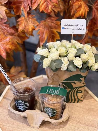 تقديمة ورد بورد ابيض مع كوب قهوة وكوب كيك كوكيز وك...