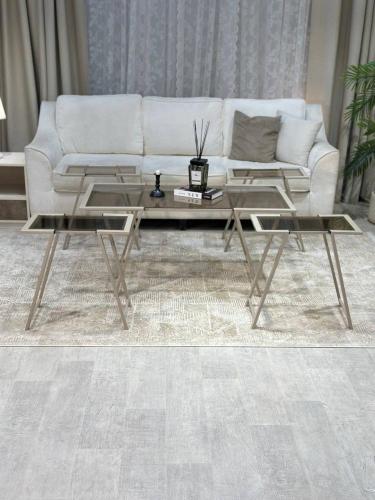 طقم طاولات شنباني أنيق بسطح زجاجي بني ولمسات معدنية فاخرة