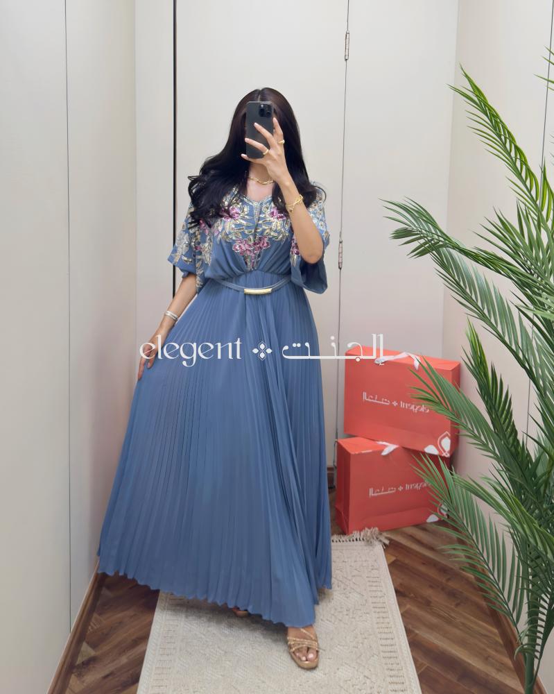 فستان سماوي مطرز بزهور لامعة ولمسات بليسيه أنيقة