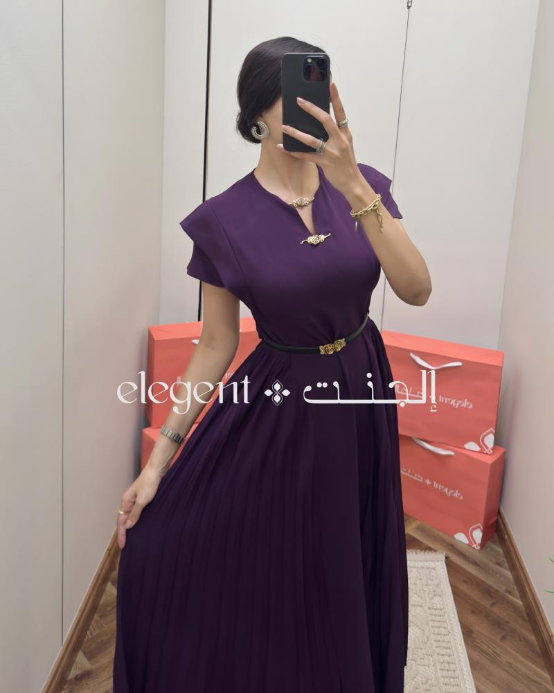 فستان بنفسجي ناعم بكسرات كلاسيكية وتفاصيل وردية ذهبية