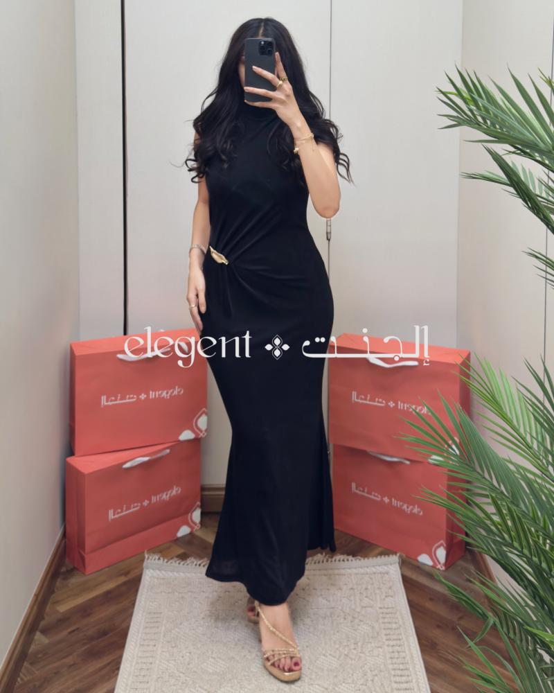 فستان أسود طويل بكسرات أنيقة على الخصر وبروش ذهبي - فساتين سهرة أنيقة