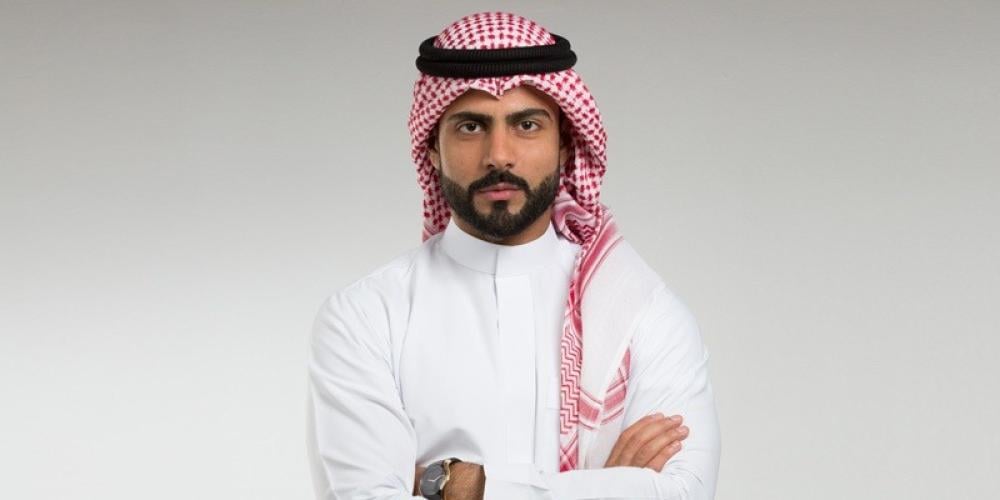 رجل سعودي يرتدي شماغ أحمر وأبيض بتنسيق رسمي وأنيق