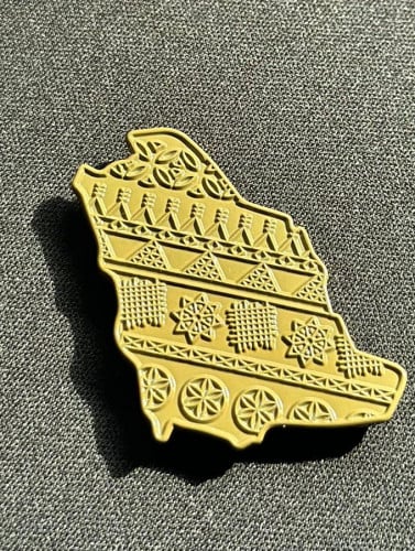 بروش بخريطة السعودية بمنقوشات من الموروث الشعبي