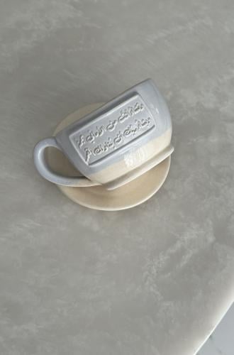 كوب مع طبق بعبارة (وتشاء أنت من الأماني نجمةً ‏ويشاء ربك أن يناولك القمر)