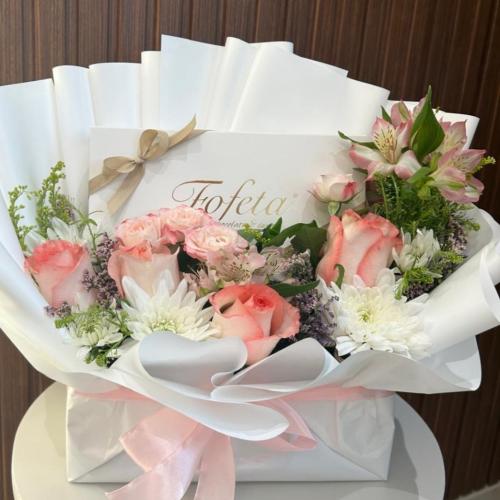 باقة ورد طبيعي فيها علبة شكولاتة