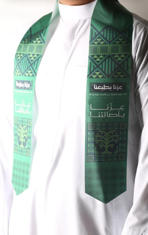 شال اليوم الوطني بشعار عزنا بطبعنا