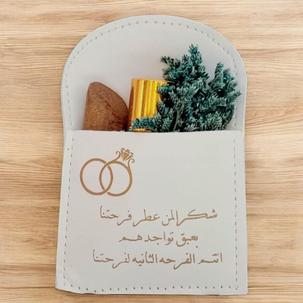 جيوب الجلد لون أبيض (12 قطعة) مع تولة مسك وكسرة عود ومنسق بالورد وعبارة شكرًا لمن عطر فرحتنا بعبق تواجدهم انتم الفرحة الثانية لفرحتنا