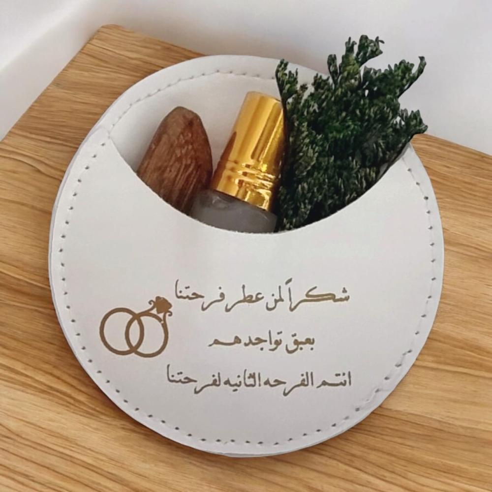 جيوب الجلد لون أبيض (12 قطعة) مع تولة مسك وكسرة عود ومنسق بالورد وعبارة شكرًا لمن عطر فرحتنا بعبق تواجدهم انتم الفرحة الثانية لفرحتنا