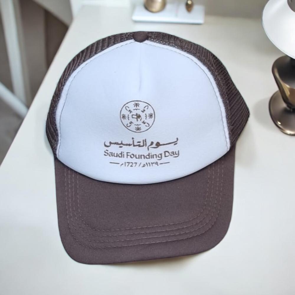 مجموعة من 12 قطعة من كابات باللون البني وعليها شعار يوم التأسيس