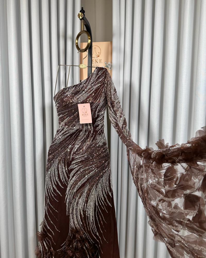 فستان سهرة بني مطرز بكتف واحد مع كم طويل شفاف فستان سهرة بني مطرز بكتف واحد مع كم طويل شفاف