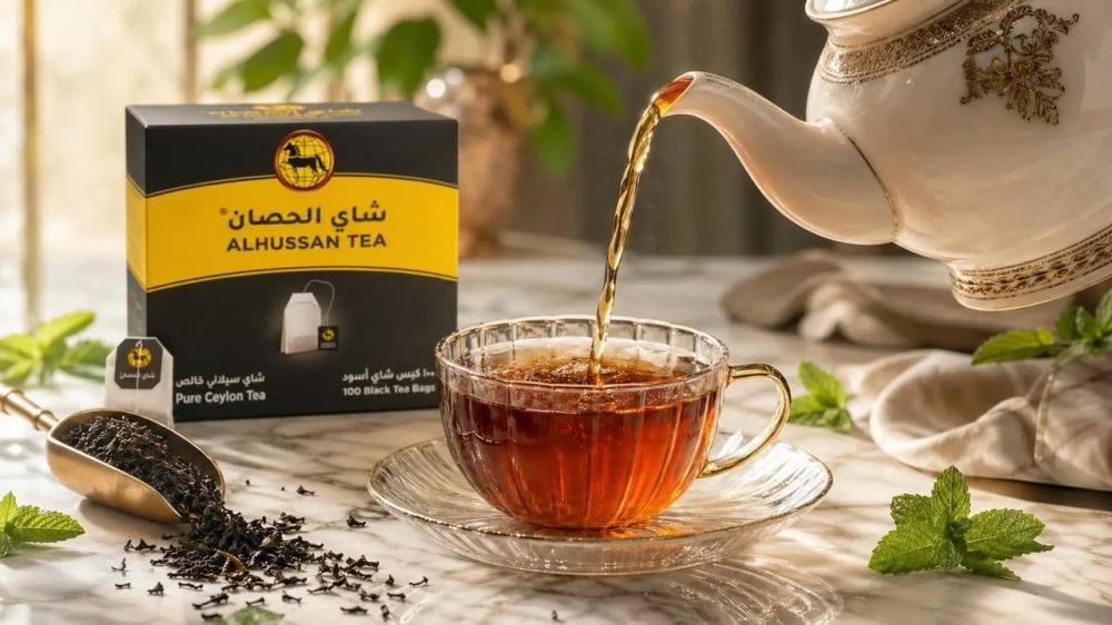 صب شاي سيلاني أسود فاخر من إبريق كلاسيكي في كوب زجاجي مع علبة شاي الحص