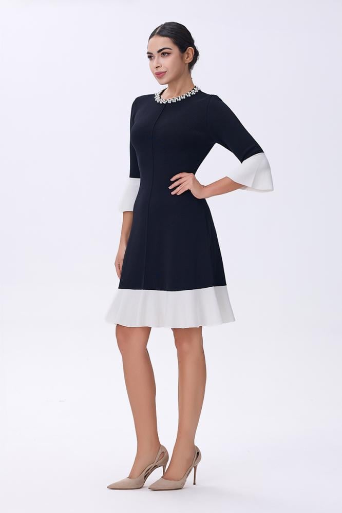 فستان أسود بأطراف بيضاء وياقة مرصعة بالأحجار