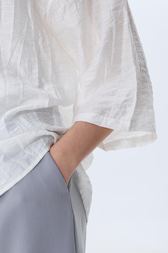 بلوزة بلون أبيض وأكمام واسعة