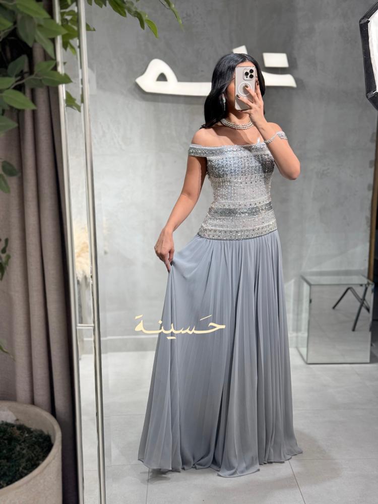 فستان فضي مطرز بالكريستال وأكتاف مكشوفة