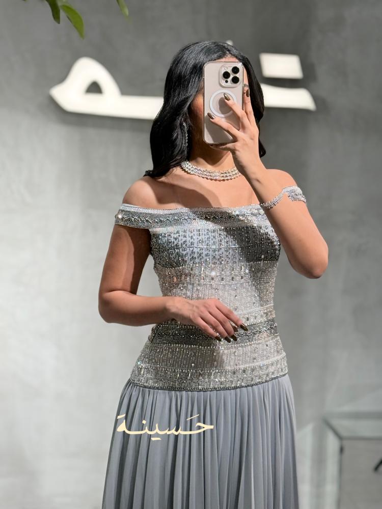فستان فضي مطرز بالكريستال وأكتاف مكشوفة