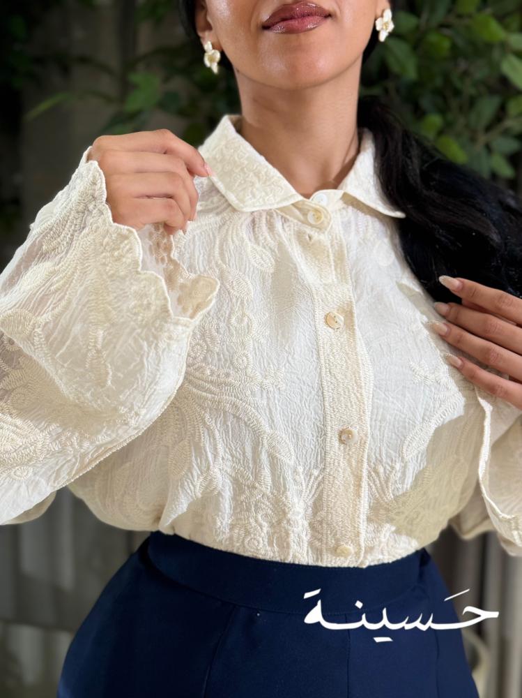Off-white blouse with delicate embroidery and classic rose details