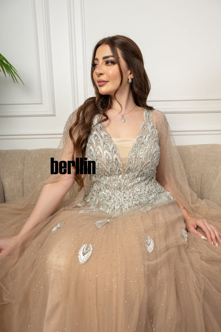 فستان سهرة مطرز من خامة التل الامع بأكمام كيب لون سماوي