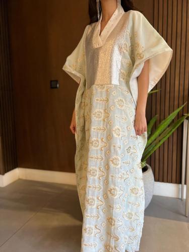 Ladies kaftan with embroidery and sequins behind lenin