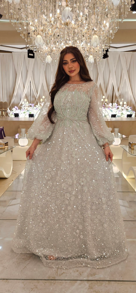 فستان سهرة فضي مطرز بالكامل بخيوط لامعة وزهور ناعمة بتصميم ملكي