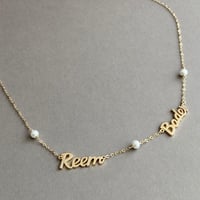 عقد إسمين أو اكثر مزين بلؤلؤ