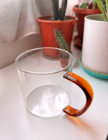 A transparent cup with a brown handle