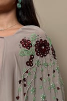 فستان ترابي بتطريز ورود عنابي وتفاصيل خرز فاخرة