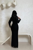 فستان أسود بلمعة ناعمة وتفاصيل مطرّزة بالأكمام